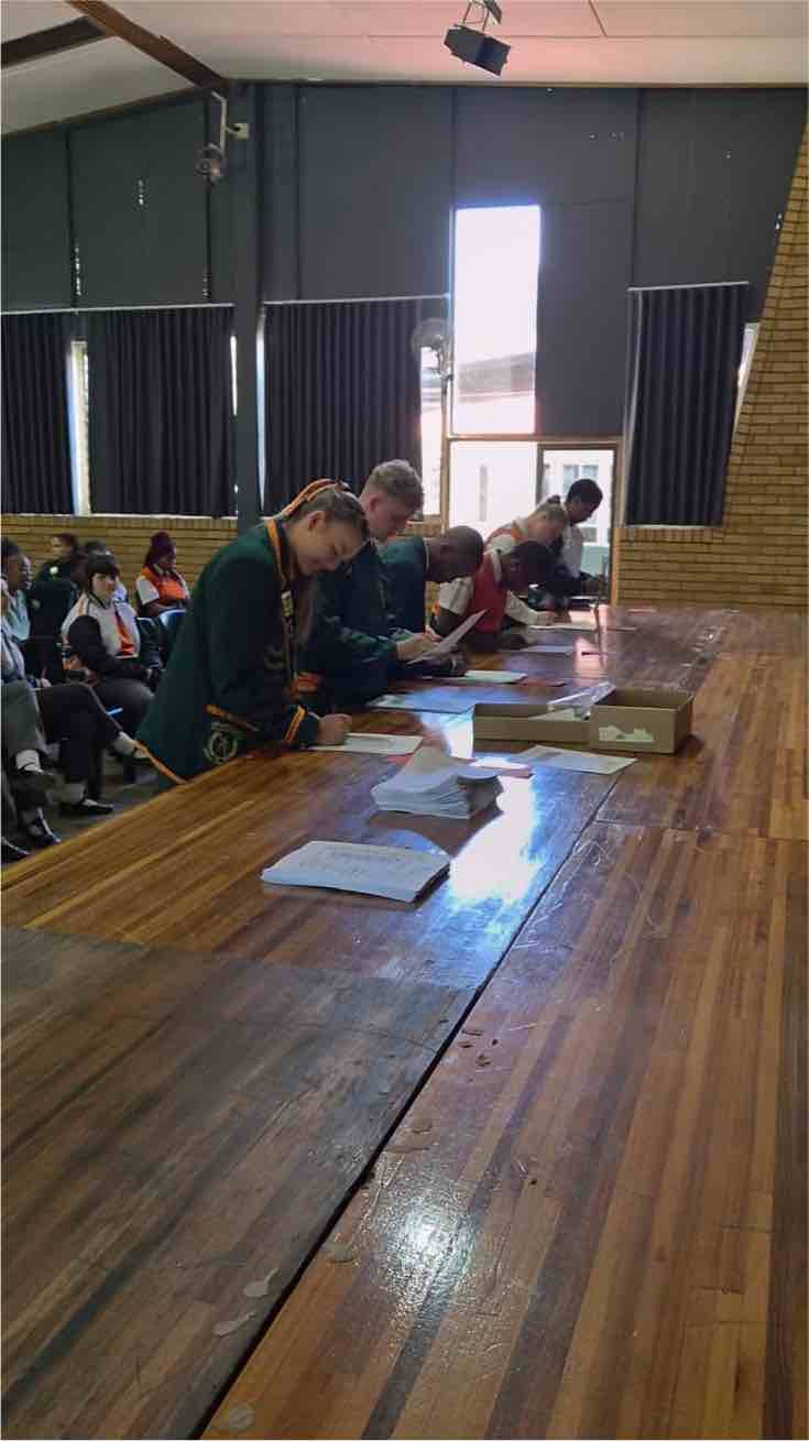 A Matric learner signs the Pledge in the school hall