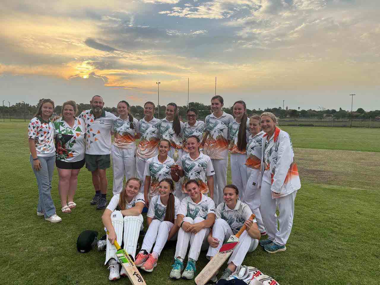 The Vossies girls cricket team and coaches with the league trophy