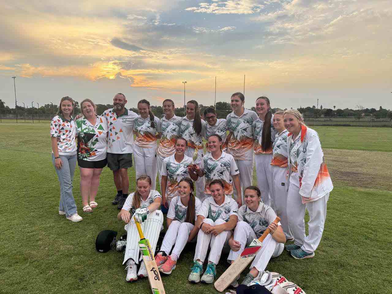 The Vossies girls cricket team and coaches with the league trophy