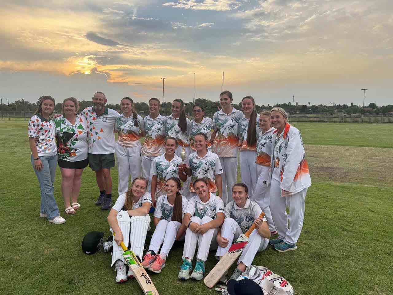 The Vossies girls cricket team and coaches with the league trophy